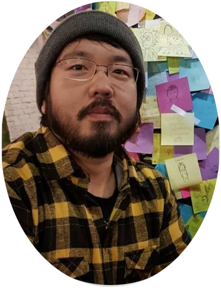 Eric wearing a black and yellow plaid shirt and a gray beanie, with glasses and a beard.